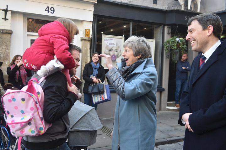  Theresa May waves at two-year-old Scarlett Ward as she walks through Salisbury