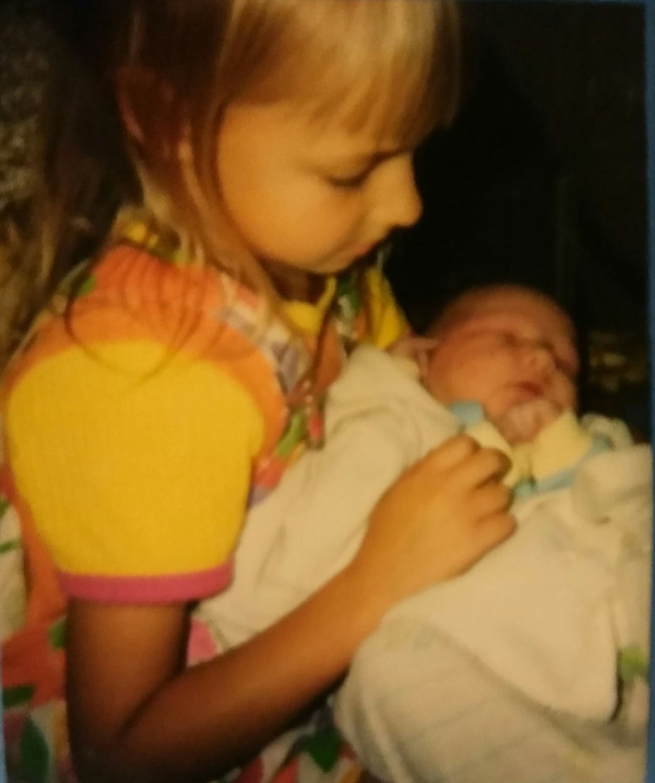 The author, age 5, holding baby No. 6, Micah, after a home birth in Kent, Minnesota, in 1997.