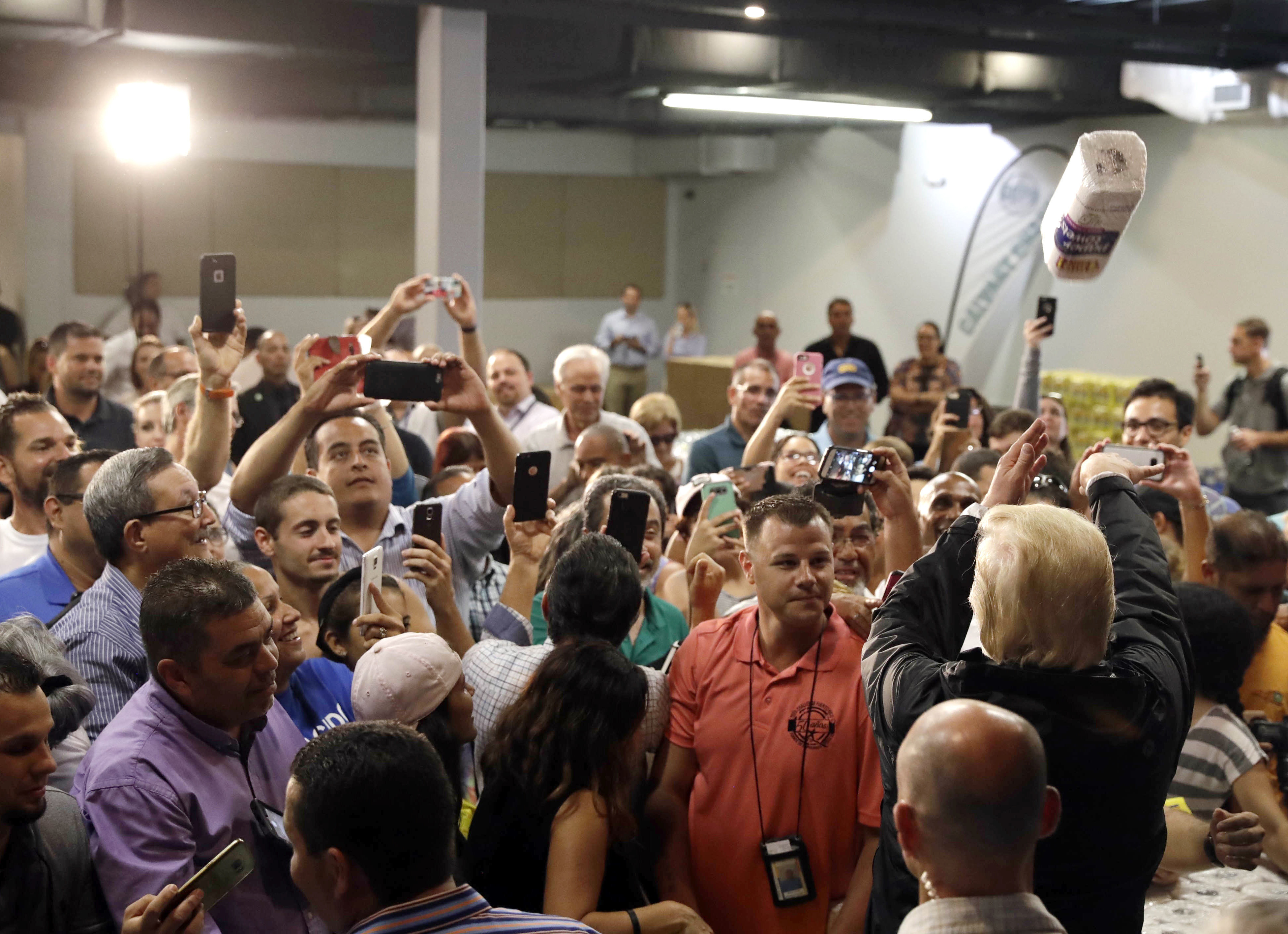 President Trump throws a roll of paper towels to a crowd affected by Hurricane Maria as he visits a disaster relief distribution center in San Juan, Puerto Rico, Oct. 3, 2017. (AP Photo/Evan Vucci) 