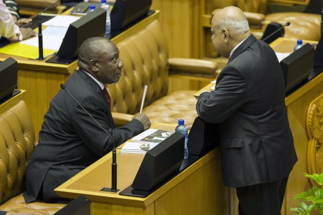 Cyril Ramaphosa, South Africa's deputy president, left, speaks to Pravin Gordhan, South Africa's finance minister, before the presentation of the 2016 budget to parliament in Cape Town, South Africa, on Wednesday, Feb. 24, 2016. Gordhan stuck to a pledge to bring down the budget deficit, targeting civil-servant jobs and increasing wealth taxes to stave off a credit-rating downgrade to junk. Photographer: Halden Krog/Bloomberg via Getty Images