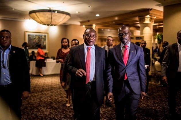 Deputy President of South Africa, and newly elected African National Congress (ANC) President, Cyril Ramaphosa (C) and Minister of Finance, Malusi Gigaba (R) flanked by security and media, leave from the Pre-World Economic Forum (WEF) Breakfast ahead of the WEF annual meetings in Davos, at the Hilton Hotel in Sandton on January 18, 2018.
