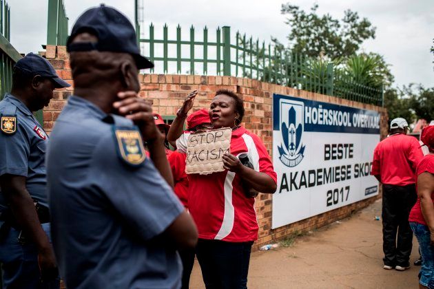 A member of the South African Democratic Teachers Union (SADTU) faces policemen as she takes part in a demonstration against the language and admission policies at Ho?erskool Overvaal school on January 22, 2018 in Vereeniging, south of Johannesburg. / AFP PHOTO / GULSHAN KHAN (Photo credit should read GULSHAN KHAN/AFP/Getty Images)