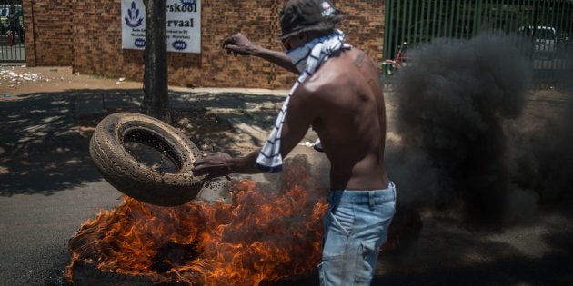 A demonstrator lights a tyre during protests outside Hoërskool Overvaal on January 17.