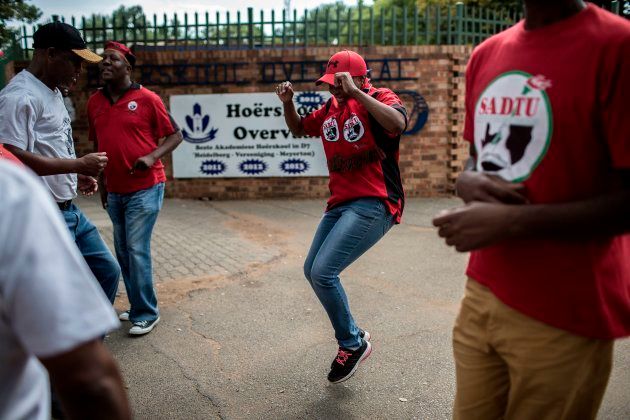 Members of the South African Democratic Teachers Union (SADTU) dance as they demonstrate outside Höerskool Overvaal school against the school's language and admission policies, on January 22, 2018 in Vereeniging, south of Johannesburg.