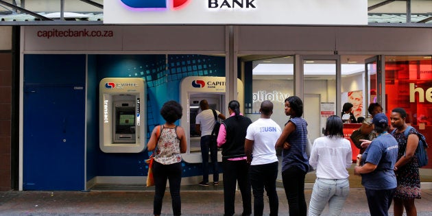 Customers queue to draw money from an ATM outside a branch of South Africa's Capitec Bank in Cape Town in this picture taken March 15, 2016. REUTERS/Mike Hutchings