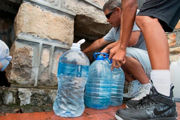 People collect drinking water from pipes fed by an underground spring, in St. James, about 25 kilometres from Cape Town's city centre, on Jan. 19, 2018.