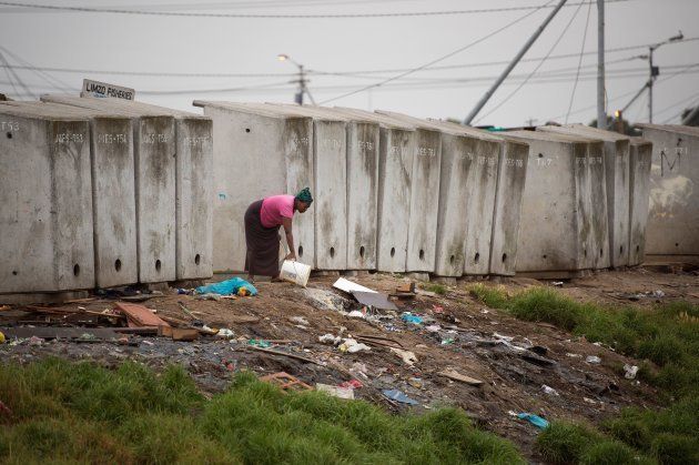 A woman throws out waste water next to a line of toilets in an informal settlement in Langa, a mostly impoverished township, about 10 kilometres from the centre of Cape Town, on Nov. 12, 2017.