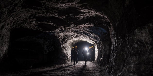 Group of men in a dark mine underground - mining concepts