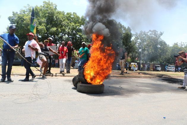 Protesters burn a tyre outside the school.