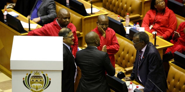 Opposition party leaders Mmusi Maimane (DA party), Julius Malema (EFF party) and Mangosuthu Buthelezi (IFP party) confer shortly before voting during the motion of no confidence against South African president Jacob Zuma in parliament last year.