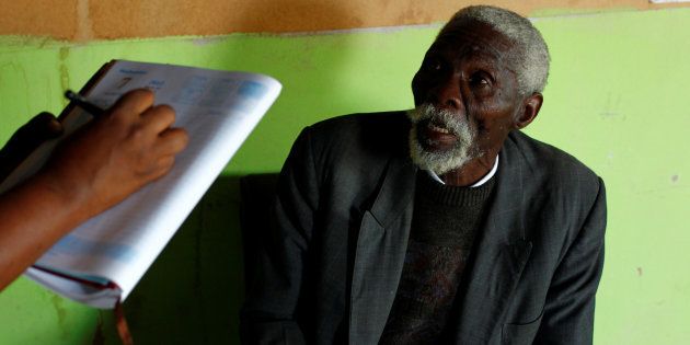 Former gold miner Senzele Silewise, 81, diagnosed with silicosis, talks to paralegals in Bizana in South Africa's impoverished Eastern Cape province March 7, 2012. REUTERS/Mike Hutchings/File Photo
