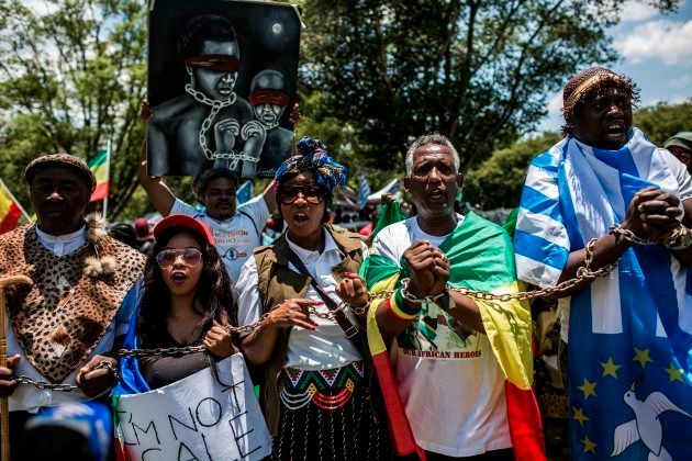 Members of the Africa Diaspora Forum (ADF), civil society organisations, churches, trade unions and other coalitions wear chains and shout slogans during a demonstration against the slave trade and human trafficking in Libya on December 12, 2017 at the Union Buildings in Pretoria.