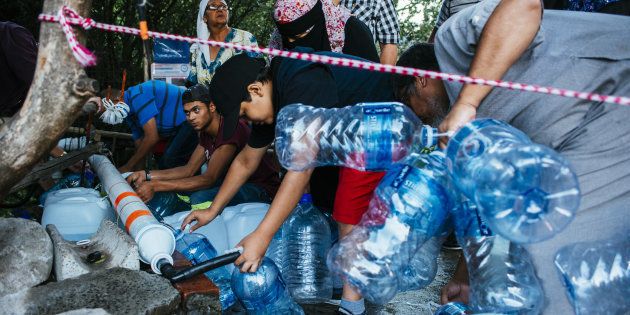 Residents collect water from a pipe to fill plastic water bottles at the Newlands natural water spring in Cape Town, South Africa, on Wednesday, Feb. 7, 2018.