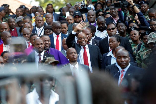 Jacob Zuma waves to his supporters on his way the high court in Durban