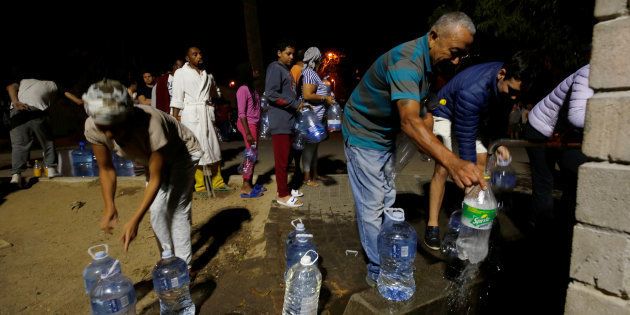 People queue to collect water from a spring in the Newlands suburb as fears over the city's water crisis grow in Cape Town. January 25, 2018.