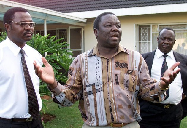 Opposition Movement for Democratic Change (MDC) President Morgan Tsvangirai flanked by his lawyer Innocent Chigunda (L) and MDC Vice President Gibson Sibanda (R) speaks to journalists February 25, 2002. Tsvangirai has been charged with treason over government allegations that he allegedly plotted to assassinate President Robert Mugabe. Tsvangirai has denied the charges. REUTERS/Howard Burditt REUTERS HB
