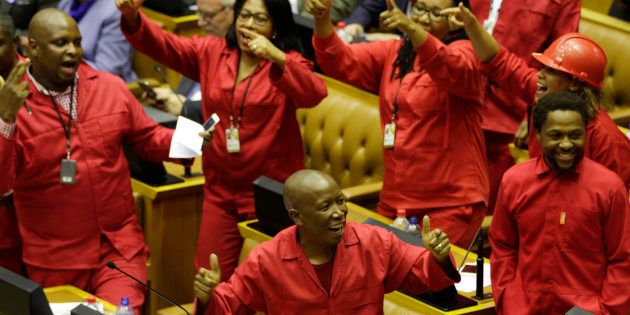 EFF leader Julias Malema (C, bottom) celebrates prior to an unsuccessful vote of no-confidence against President Jacob Zuma on August 8, 2017 in the South African National Assembly in Cape Town.