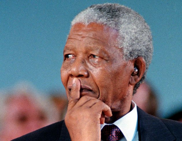 Then South African President Nelson Mandela smiles during a specially convened Harvard University ceremony honoring him in this September 18, 1998 file photo taken in Harvard Yard in Cambridge, Massachusetts.