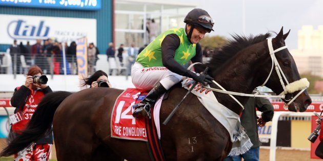 Jockey Pierre Strydom riding The Conglomerate smiles after winning the Durban July horse race on July 2, 2016, in Durban. The Durban July is the biggest horse racing event on the African continent and attracts close to 55,000 spectators. Bets are placed in excess of an estimated R200 million.