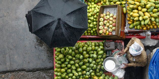 A vendor sells fruits during a heavy monsoon rain shower in New Delhi.