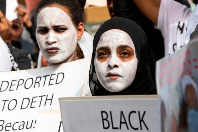 African migrants demonstrate with white paint on their faces, outside the Embassy of Rwanda in the Israeli city of Herzliya on February 7, 2018, against the Israeli government's policy to forcibly deport African refugees and asylum seekers to Rwanda and Uganda.