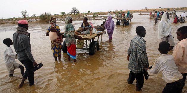 Displaced people carry their belongings to get away from flood during heavy rain at Nyala locality in South Darfur, Sudan earlier this month.