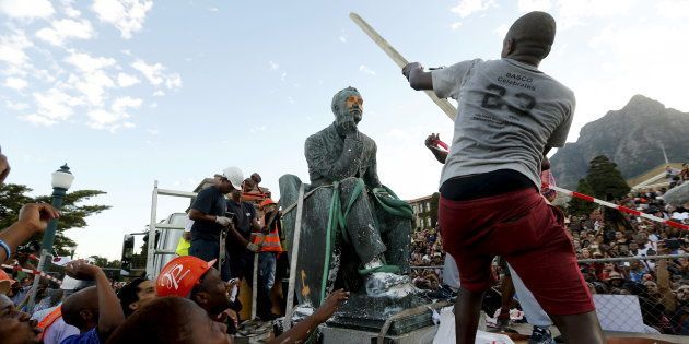 A student hits the statue of Cecil John Rhodes with a stick as it is removed from the University of Cape Town (UCT), April 9, 2015.