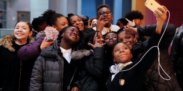 A group of children take a selfie as they arrive on the opening night of