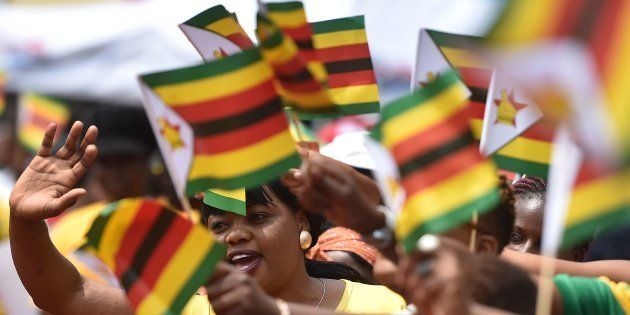 People react as Zimbabwe's President Emmerson Mnangagwa is sworn-in during a ceremony in Harare on November 24, 2017.