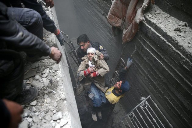 Civil defence help an unconscious woman from a shelter in the besieged town of Douma in eastern Ghouta in Damascus, Syria, February 22, 2018.