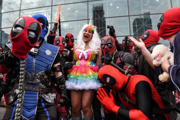 A woman dressed as a unicorn poses for a photograph with a group dressed as Deadpool during New York Comic Con in New York City, U.S. October 7, 2017. REUTERS/Stephanie Keith
