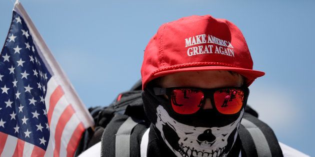 A masked demonstrator in a Donald Trump