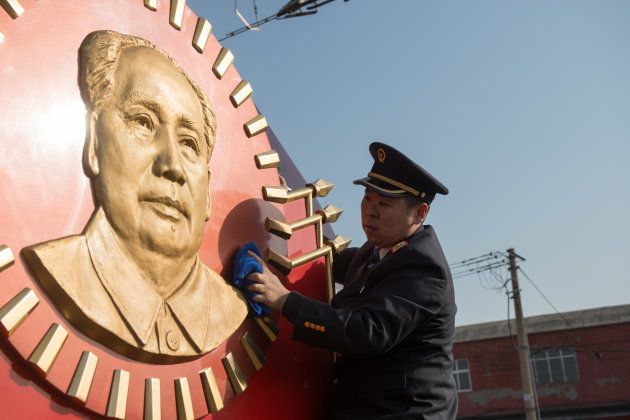 A railway worker cleans a train named after Mao Zedong beside a railway platform on February 1, 2018 in Beijing, China. With a locomotive featuring gold-plating head portrait of Chairman Mao Zedong, the train also serves passenger line linking Beijing and Changsha during Spring Festival travel rush.