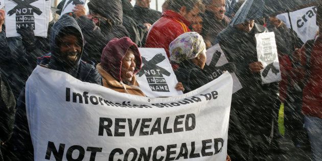 Demonstrators protest in the rain against the decision by public broadcaster the South African Broadcasting Corporation (SABC) that it would not broadcast scenes of violent protest, in Cape Town, South Africa, July 1, 2016.