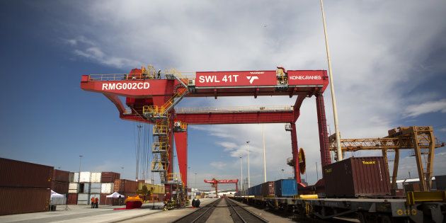 A loading crane straddles a freight rail track near shipping containers on the opening day of Transnet SOC Ltd.'s new container handling terminal at City Deep inland port in Johannesburg, South Africa, on Thursday, Nov. 26, 2015. Transnet plans to spend as much as 380 billion rand over the next decade to expand and upgrade rail and port capacity in South Africa, the world's biggest manganese producer and the continents largest source of iron ore and coal. Photographer: Karel Prinsloo/Bloomberg via Getty Images