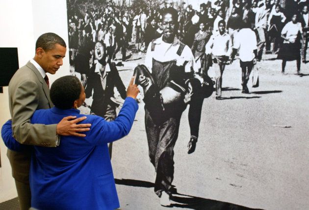 U.S.Senator Barack Obama (L) looks at a photo with Antoinette Sithole, sister of Hector Pietersen, at the Hector Pietersen Museum in Soweto, South Africa August 23, 2006.