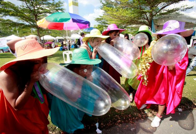Members of Swing Service Workers in Group, a non-profit organisation for sex workers, blow condoms during a campaign to stop the spread of AIDS ahead of World AIDS Day, in Bangkok November 29, 2009.