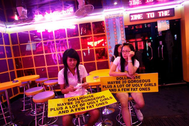 Thai go-go dancers wait for customers at Bangkok's normally packed Soi Cowboy red-light area just before curfew May 25, 2010.