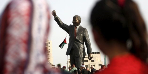 People look at a Mandela statue during the inauguration of Nelson Mandela Square in the West Bank city of Ramallah April 26, 2016.