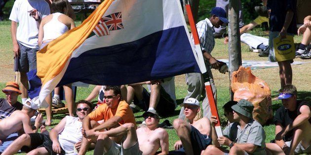 A South African cricket fan waves an apartheid-era South African flag at a Test match against New Zealand on November 21, 2000, in Bloemfontein.