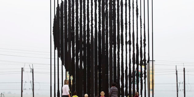 Community members visit a memorial on the anniversary of the death of former South African President Nelson Mandela at the site of his arrest in Howick, 5 December, 2014. South Africa marked the first anniversary of former President Nelson Mandela's death on Friday with tributes to his struggle against white-minority rule and sober reflections on the country's failure to capitalise on the freedom he fought for. REUTERS/Rogan Ward (SOUTH AFRICA - Tags: POLITICS ANNIVERSARY SOCIETY)