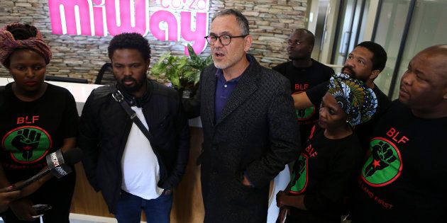 Black First Land First (BLF) leader Andile Mngxitama (2nd L) and BLF members listen to MiWay Insurance Company CEO Rene Otto (C) following a meeting in Centurion on July 21, 2017, after BLF members held a picket to protest against a racist email allegedly written by one of the company's employees.