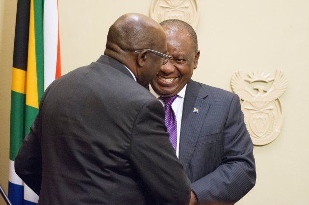 South African President Cyril Ramaphosa (R) shakes hands with newly appointed Finance Minister Nhlanhla Nene during as new cabinet ministers are sworn-in at the South African parliament in Cape Town on February 27, 2018.