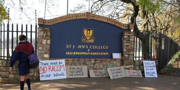 A student reads placards left at the entrance of the St. John's College in Johannesburg, South Africa, July 28, 2017.