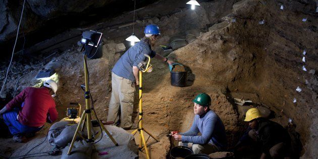 Dr. Curtis Marean (c) works with his colleagues inside a cave called PP13B on May 26, 2010, at Pinnacle Point near Mossel Bay South Africa.