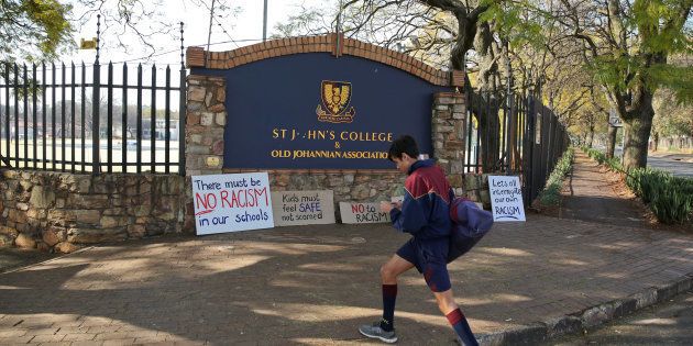 A student walks past placards left at the entrance of the St John's College in Johannesburg.