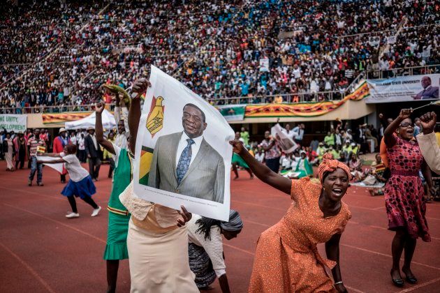 Supporters hold poster of the newly sworn-in President Emmerson Mnangagwa during the Inauguration ceremony at the National Sport Stadium in Harare, on November 24, 2017. MARCO LONGARI/AFP/Getty Images