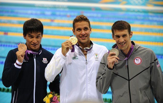 Gold Medalist South Africa's Chad le Clos (centre), Silver Medalist USA's Michael Phelps (right) and Bronze Medalist Japan's Takeshi Matsuda receive their medals after the Men's 200m Butterfly