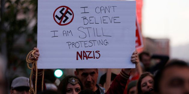 A demonstrator holds signs during a rally in response to the Charlottesville, Virginia car attack on counter-protesters after the