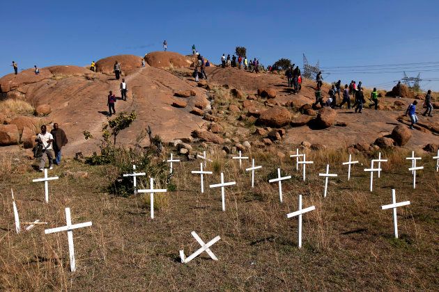 Members of the mining community walk near crosses placed at a hill known as the "Hill of Horror", where 43 miners died during clashes with police, during a strike at Lonmin's Marikana platinum mine in Rustenburg, 100 km (62 miles) northwest of Johannesburg, May 14, 2013. REUTERS/Siphiwe Sibeko